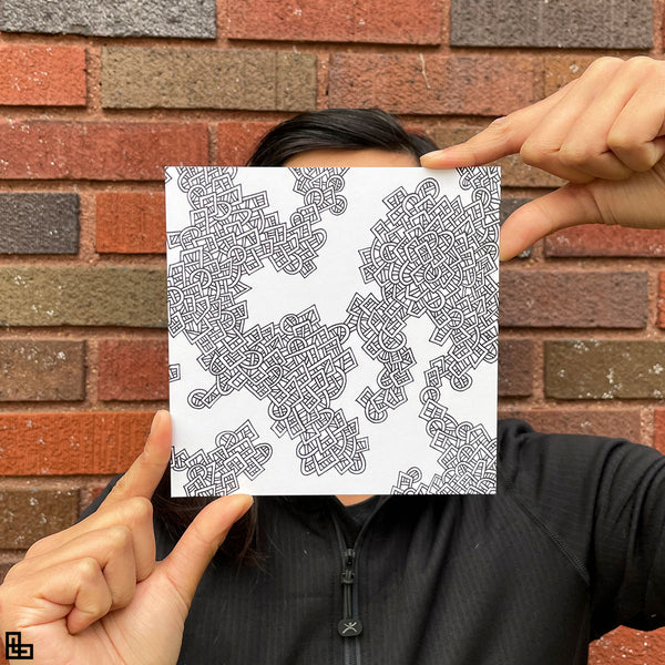Photo of a human holding this specific LLLinked square. The lines of LLLinked are drawn by hand. Each square is 6"x6", cut, labeled, signed, and stamped by hand. Each LLLinked square has a unique QR code/RFID label. No two squares are the same. Owners can register and connect with other owners at LLLinked.art.