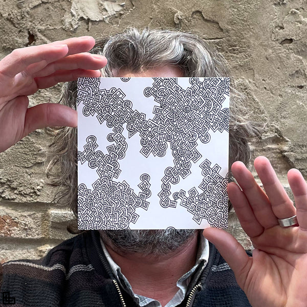 Photo of a human holding this specific LLLinked square. The lines of LLLinked are drawn by hand. Each square is 6"x6", cut, labeled, signed, and stamped by hand. Each LLLinked square has a unique QR code/RFID label. No two squares are the same. Owners can register and connect with other owners at LLLinked.art.